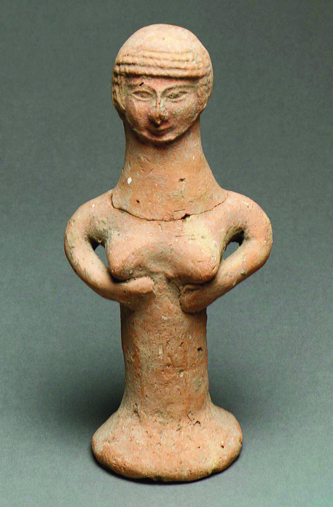 Terra-cotta pillar figurine of woman smiling slightly.