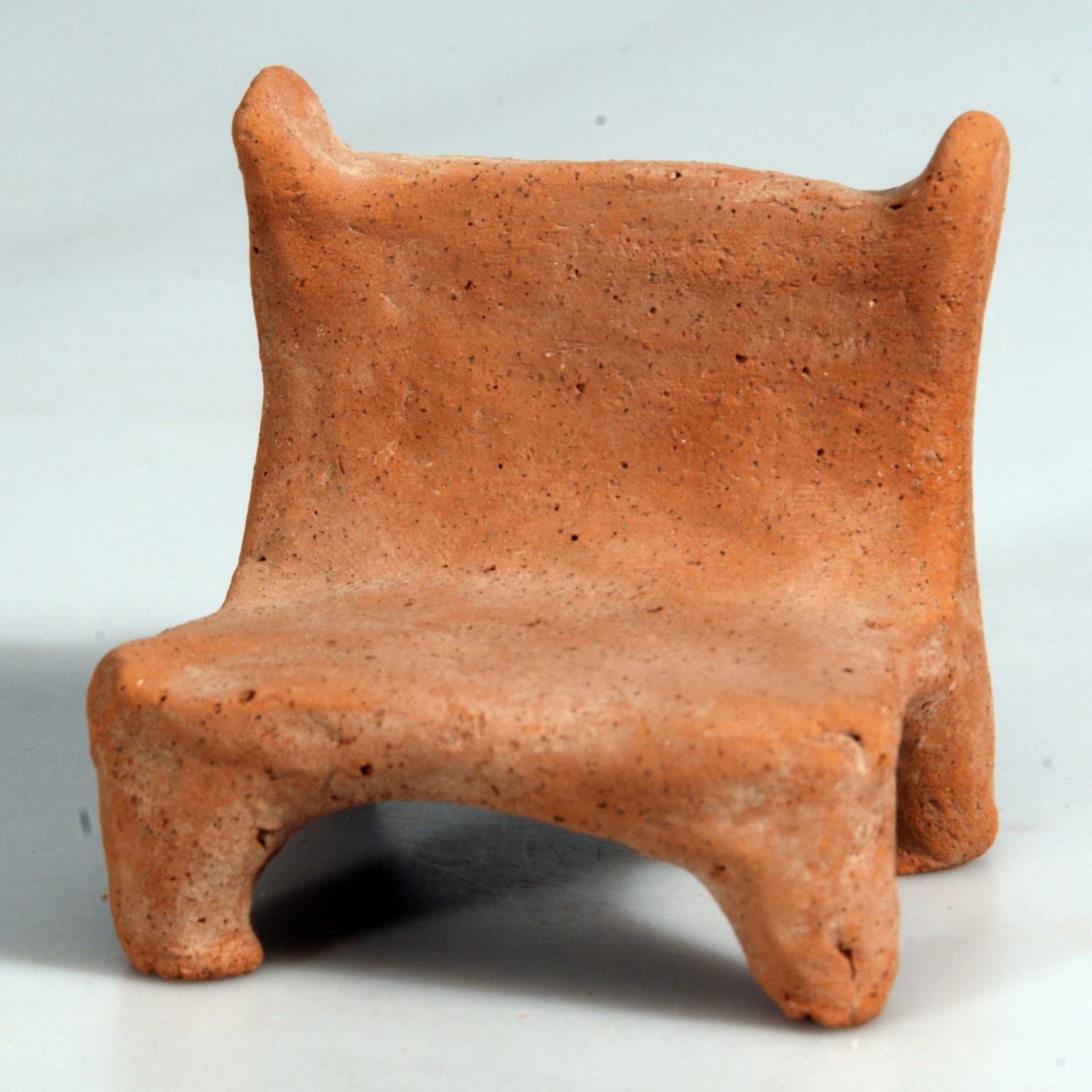 Terra-cotta chair with four short legs.