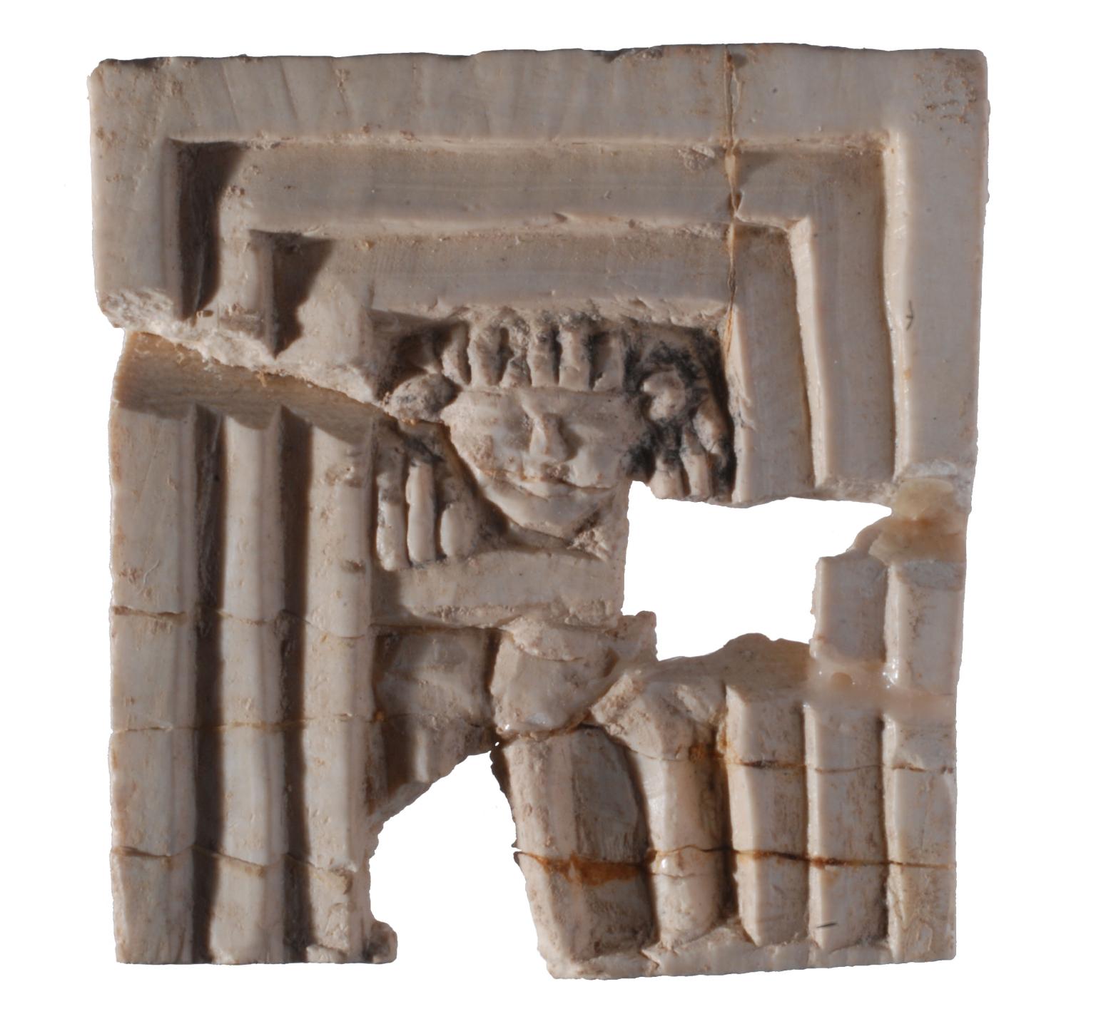 Square-shaped ivory relief of a face in a triple-recessed frame.