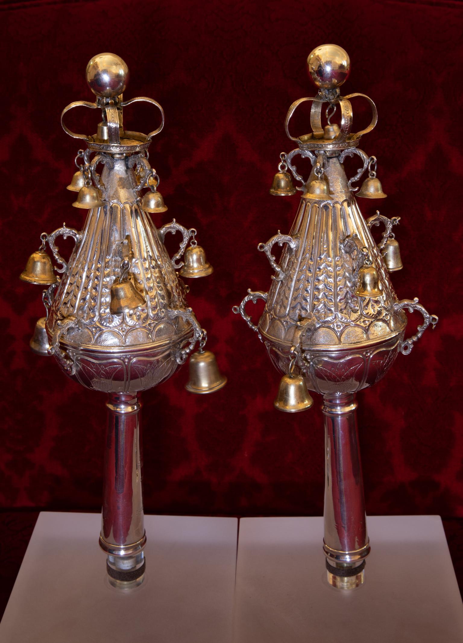 Two silver finials with bells. 