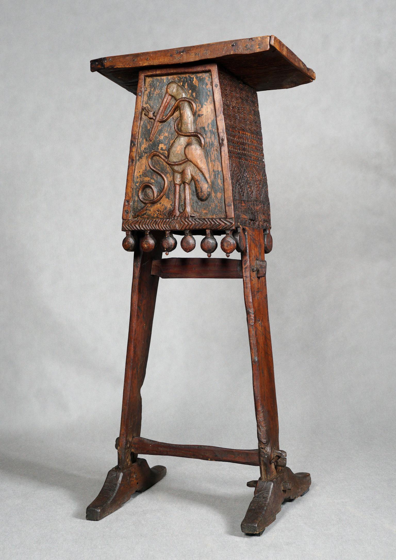 Wooden lectern with stork carving.