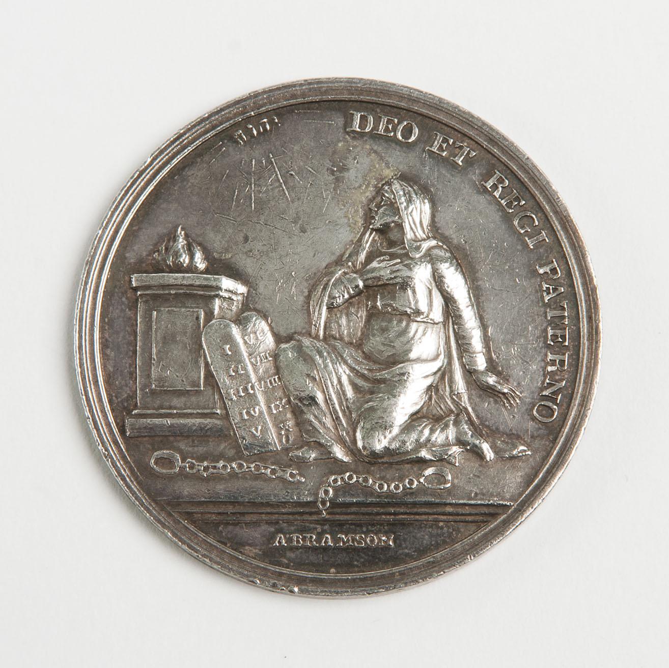 Medal featuring seated person next to Hebrew tablets and Latin text around.