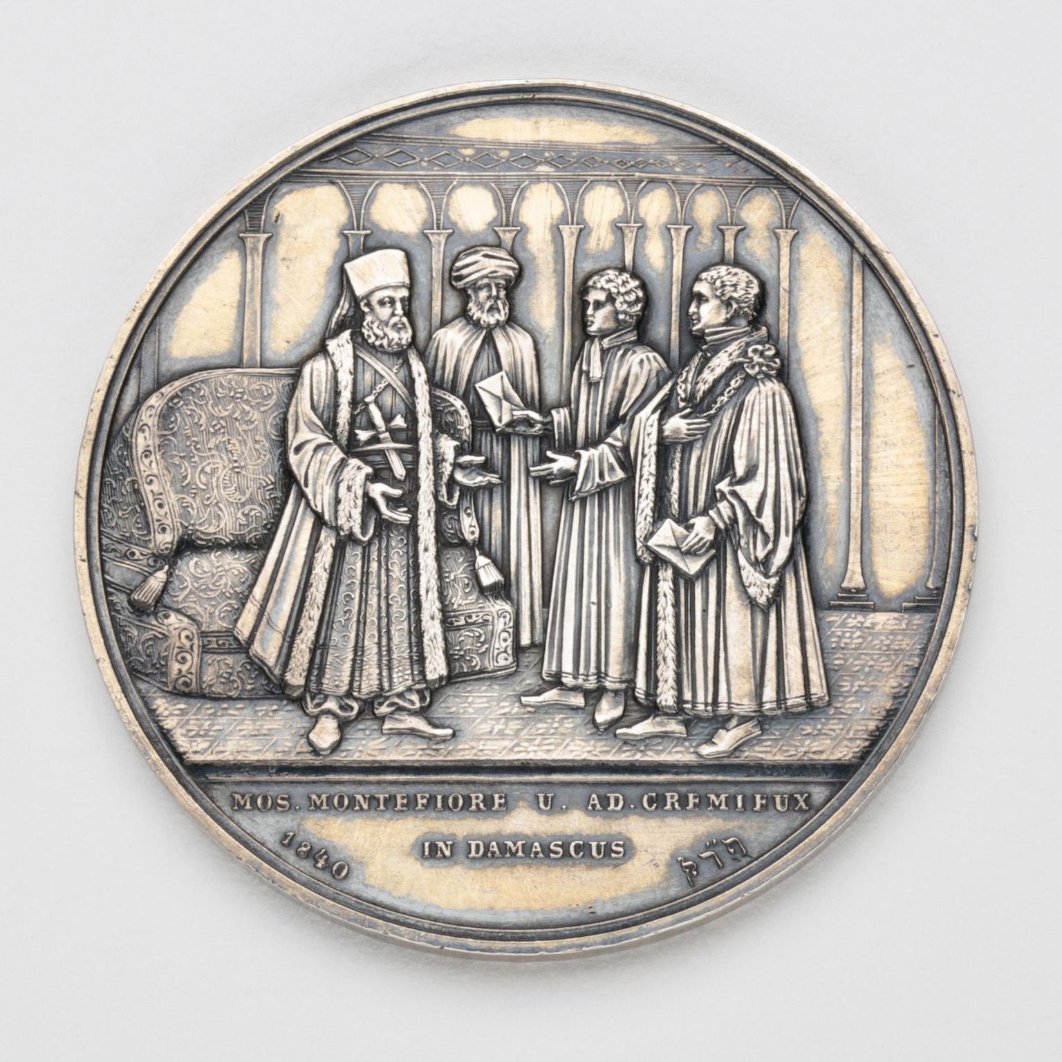 Silver medal depicting four men talking.