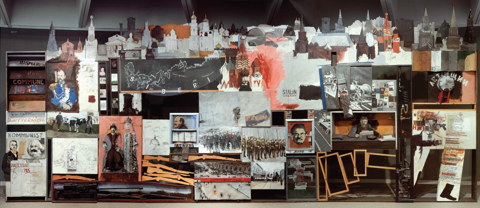 Mixed media installation featuring photos, images, frames, and cut-outs depicting soldiers in a row, profiles of male faces, maps, and informational text. 