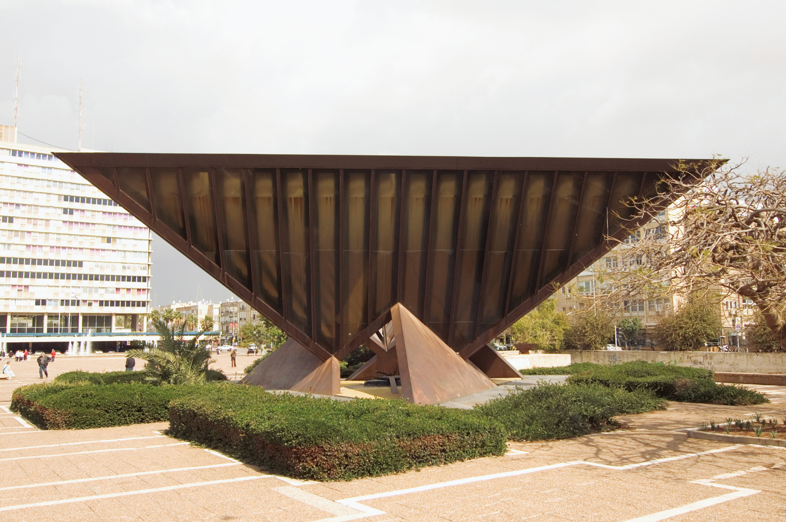 Photograph of inverted pyramid sculpture in the middle of a city square.
