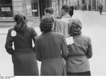 Jewish Women in the Vilna Ghetto Photo of three Jewish women wearing badges identifying them as Jewish, in the Vilna ghetto.