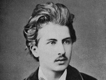Arthur Schnitzler Black and white photograph of a young man with a mustache, large bowtie, and suit jacket with light piping on the lapel..