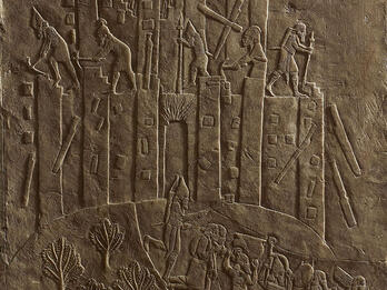Destruction of City and Capture of Inhabitants in Assyrian Relief Relief of building with figures on top and below carrying objects.