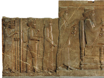 Relief of man sitting on throne with figures standing on either side.