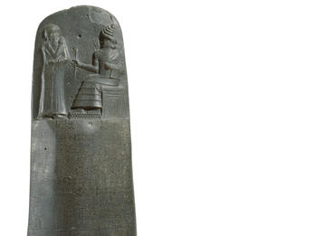 Basalt stela inscribed with Akkadian writing and figure on throne next to standing figure. Inset shows close-up of Akkadian writing. 