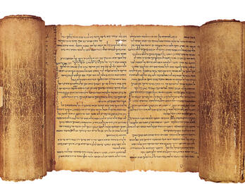 Partially unrolled scroll with page of Hebrew writing visible.