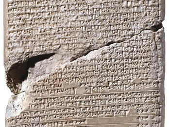 Stone tablet with large crack in middle inscribed with Akkadian writing.