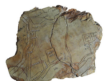 Tablet with etching of lines and squares, cracked in half.