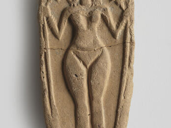 Oval clay piece with figurine of naked woman decorated with headdress, necklace, bracelets, and anklets, and holding a lotus flower.