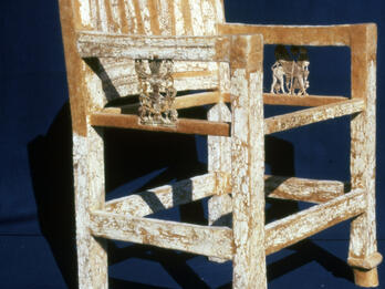 Armed chair decorated with ivory inlay including elaborate carving on arms.