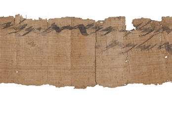 Long and narrow papyrus fragment with Hebrew writing on top. 