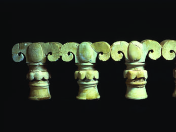 Tops of four columns shaped like palm fronds.