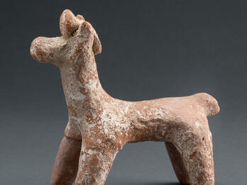 Terra-cotta figurine of horse with ornament on head.