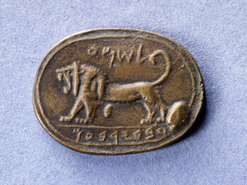 Cast of oval seal with a lion with open jaws and upward-curving tail and Hebrew inscription.