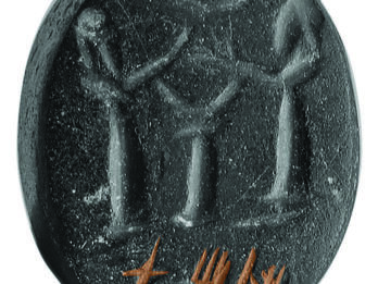 Stone seal with two bearded men with their hands raised flanking an altar or pedestal with crescents above and below their hands, and Hebrew inscription at bottom. 