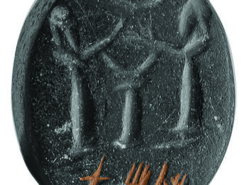 Stone seal with two bearded men with their hands raised flanking an altar or pedestal with crescents above and below their hands, and Hebrew inscription at bottom. 