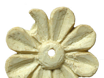 Ivory-inlay or Appliqué Piece Depicting a Rosette Ivory carving in shape of an eight-petaled flower with small hole in center.