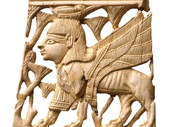 Ivory panel of lion with claws and teeth gripping bull in partial rectangular frame.