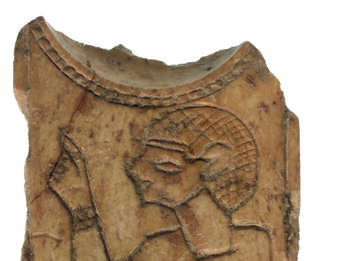 Ivory or bone spoon handle and portion of spoon bowl depicting a person wearing headdress and clothing with one arm raised, and lotus blossom to left of figure.