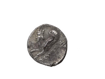Coin with Human-headed Lynx Coin with image of winged creature with human head, beard, and horns and Hebrew inscription.