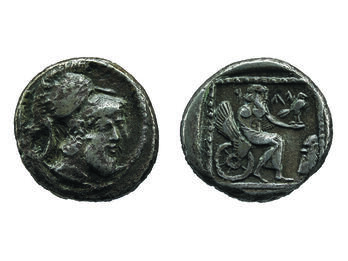 Coin with Helmeted Deity/Deity on a Winged Wheel Front of coin depicting head with beard wearing helmet and back of coin depicting figure on winged chariot holding bird.