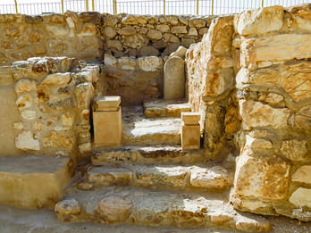 Photograph of remains of stone structure with steps and two small altars.