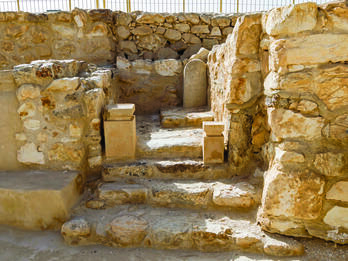 Photograph of remains of stone structure with steps and two small altars.