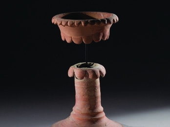Ceramic chalice with tall, hollow stand and bowl in a separate piece on top and secured to bottom of chalice with a rod.