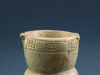 Goblet-shaped Cosmetic Container Limestone, goblet-shaped container with a footed base, a midsection with festoon pattern, and a deep bowl with checkerboard pattern on rim.