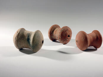 Rattles Three spool-shaped terra-cotta objects with a hole on one end.