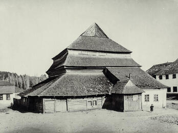 Photograph of wooden building exterior with several layers of roofs.