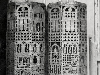 Cylindrical cases carved with geometric designs.
