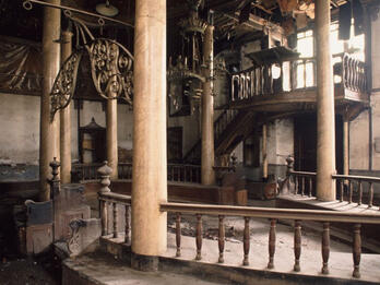 Synagogue Mejor, Bursa, Turkey Photograph of room with raised central platform with columns and several chandeliers.