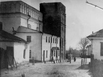 Exterior photograph of street with several buildings on left and one on right. 