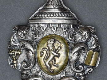 Amulet with Coat of Arms Silver amulet with designs around edge and lion in center.
