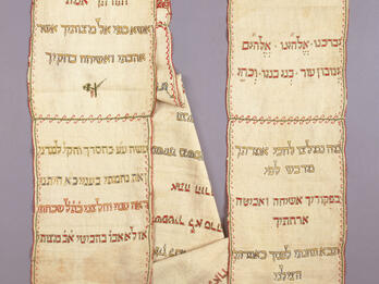 Rectangular cloth arranged in two columns embroidered with Hebrew text and small Star of David on right side. 