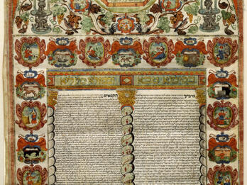 Page of Aramaic text with illustrations surrounding it, including heraldic shields around the text and a city, vines, flowers, and birds above text. 