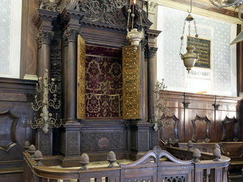 Scuola Italiana, Venice Photograph of carved Torah ark with gold doors, crown at top, and wooden fence around it.