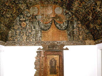 Photograph of wall and ceiling painted with vegetation and zoological motifs.
