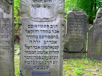 Gravestone of Ezekiel Katzenellenbogen Tombstone of relief of open books, Hebrew inscriptions, and two lanterns on ground in front.