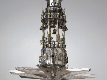 Sabbath Lamp Silver multi-tiered hanging lamp with sculpture of lion on top.