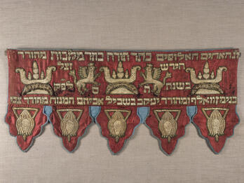 Torah Ark Valance Short curtain embroidered with Hebrew text across the top with griffins and crowns.