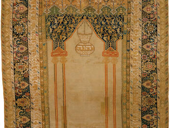 Textile with woven image of two hands at bottom beneath censer and decorative borders. 