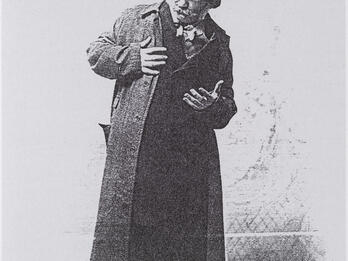 Photograph of man in top hat looking off to the side.