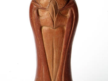 Sculpture of bearded man wearing shawl, with mouth open and hands clasped.